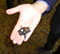 small black blast gauge held in a man's palm