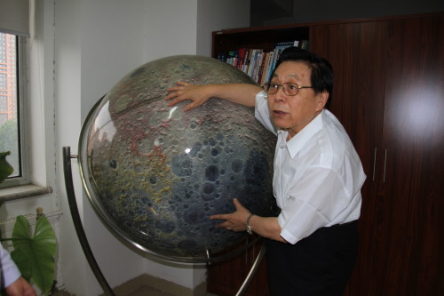 The Moon man: Ziuyan Ouyang in his office at the National Astronomical Obervatories with a lunar globe covered with images taken by Chinese craft