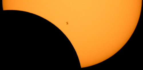 The International Space Station seen as a silhouette as it transits the Sun at roughly five miles per second during a partial solar eclipse in Northern Cascades National Park, Washington